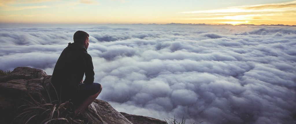 Man looking at clouds on a mountain