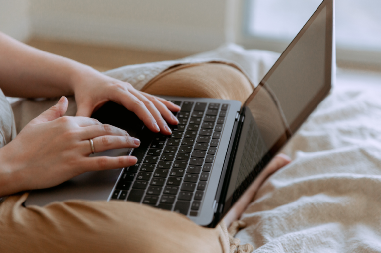 Hands typing on laptop